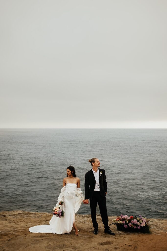 Bride and groom hold hands at their East Coast beach wedding