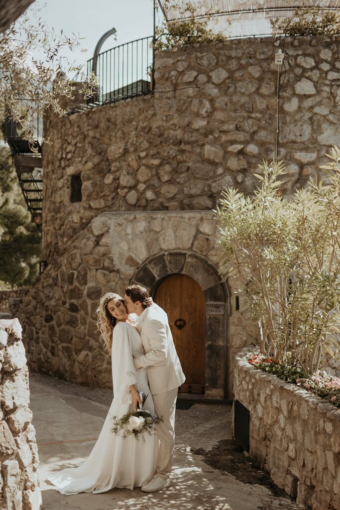 Groom kisses bride on the cheek at their Tuscan-inspired East Coast wedding venue