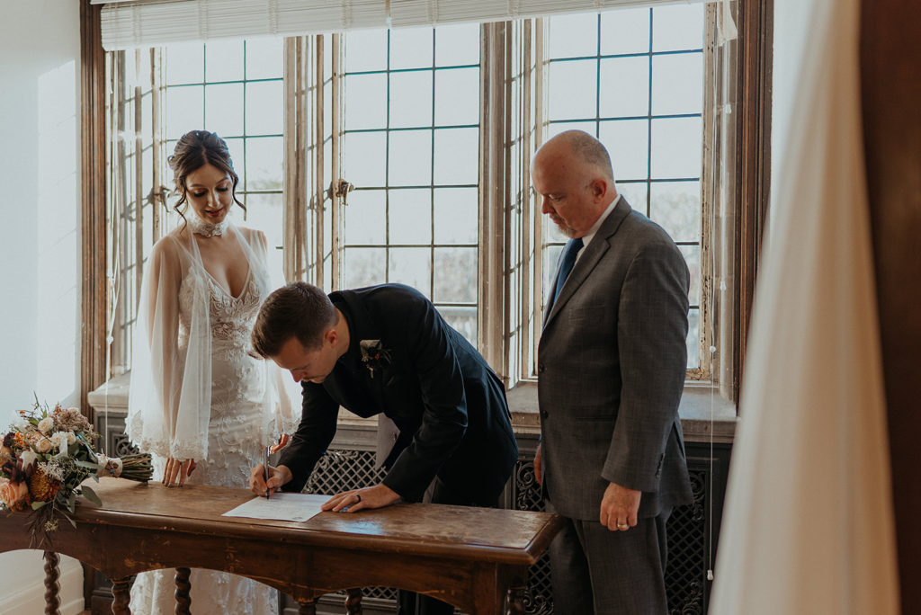 Bride and groom signing marriage license