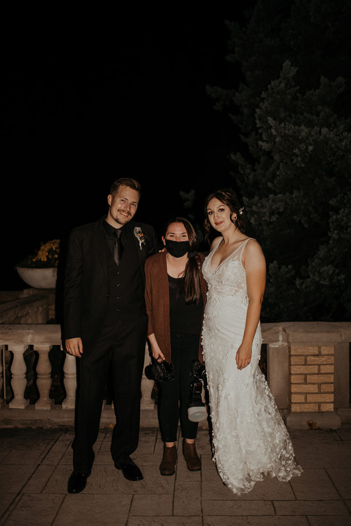 Bride,groom and wedding photographer after reception