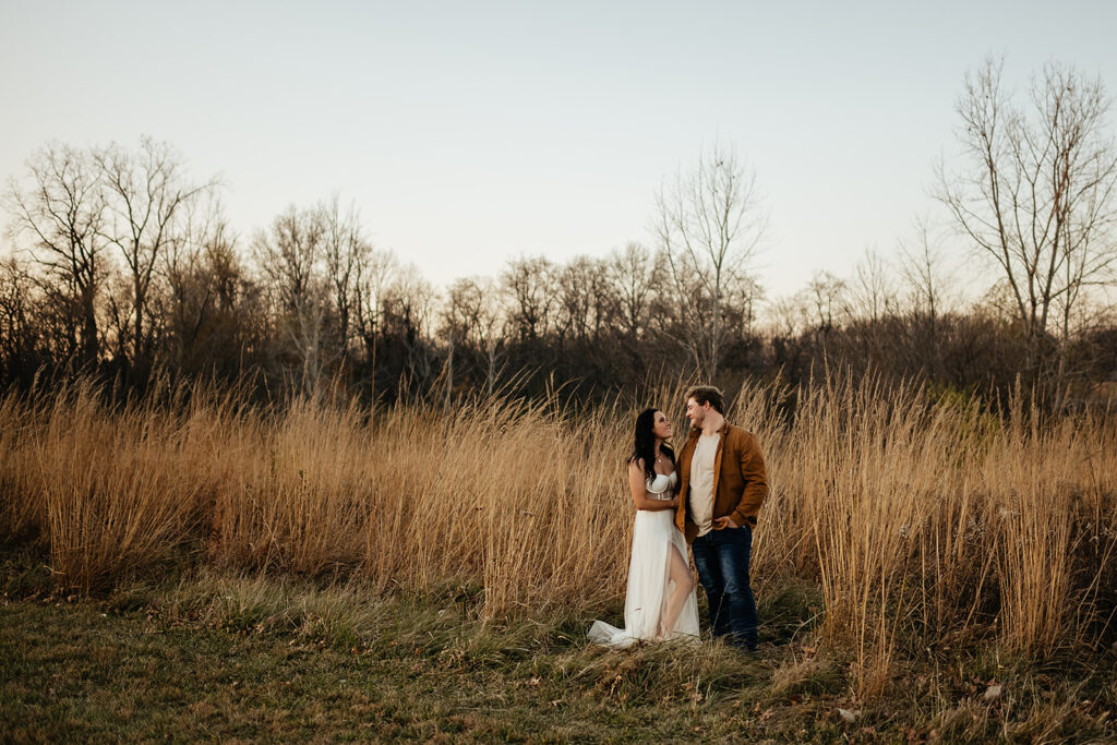 Couple posing in the tall grass during fall engagement session