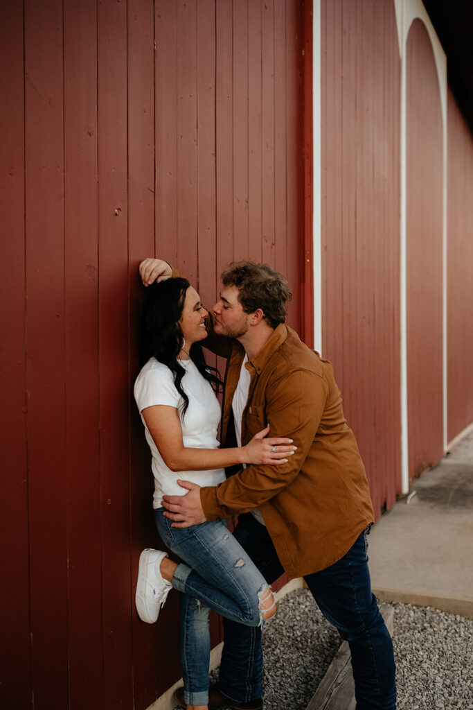 Couple posing at Soloman Farms in Fort Wayne Indiana for fall barn engagement photos