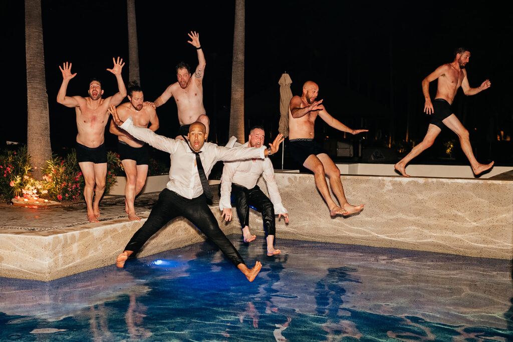 Wedding guests jumping into pool