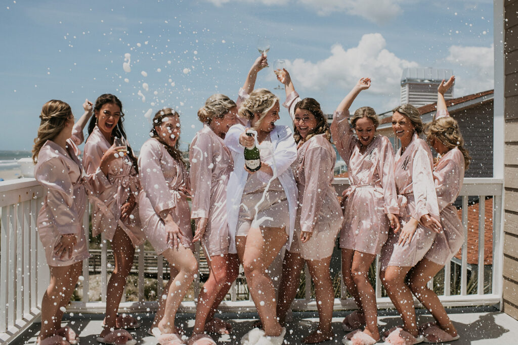 Bride and bridesmaids popping champagne