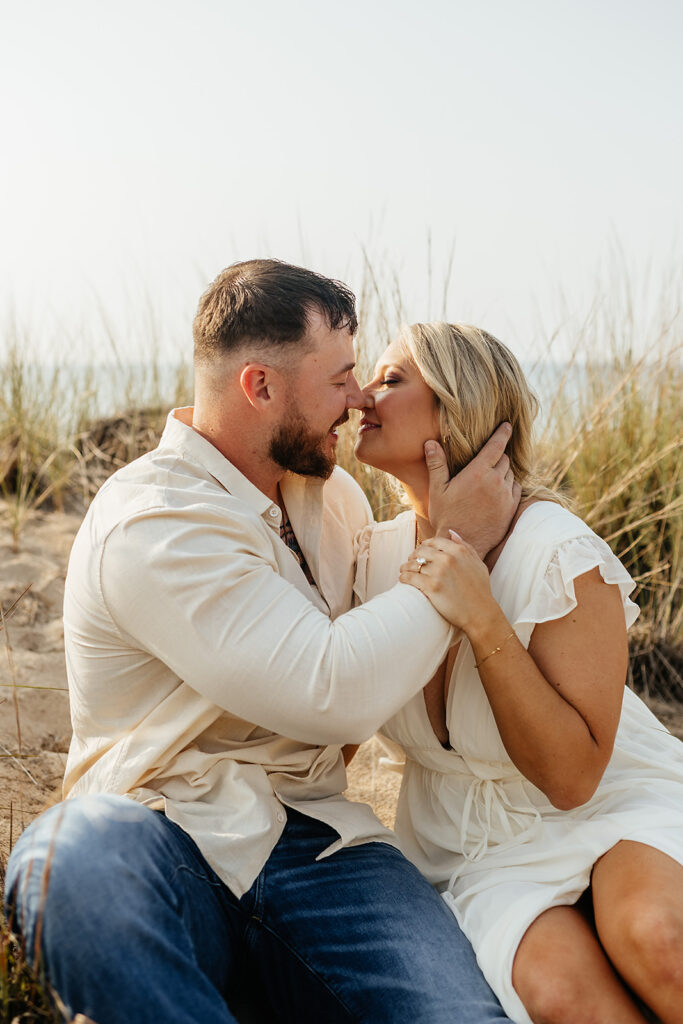 couple kissing on the beach for engagement