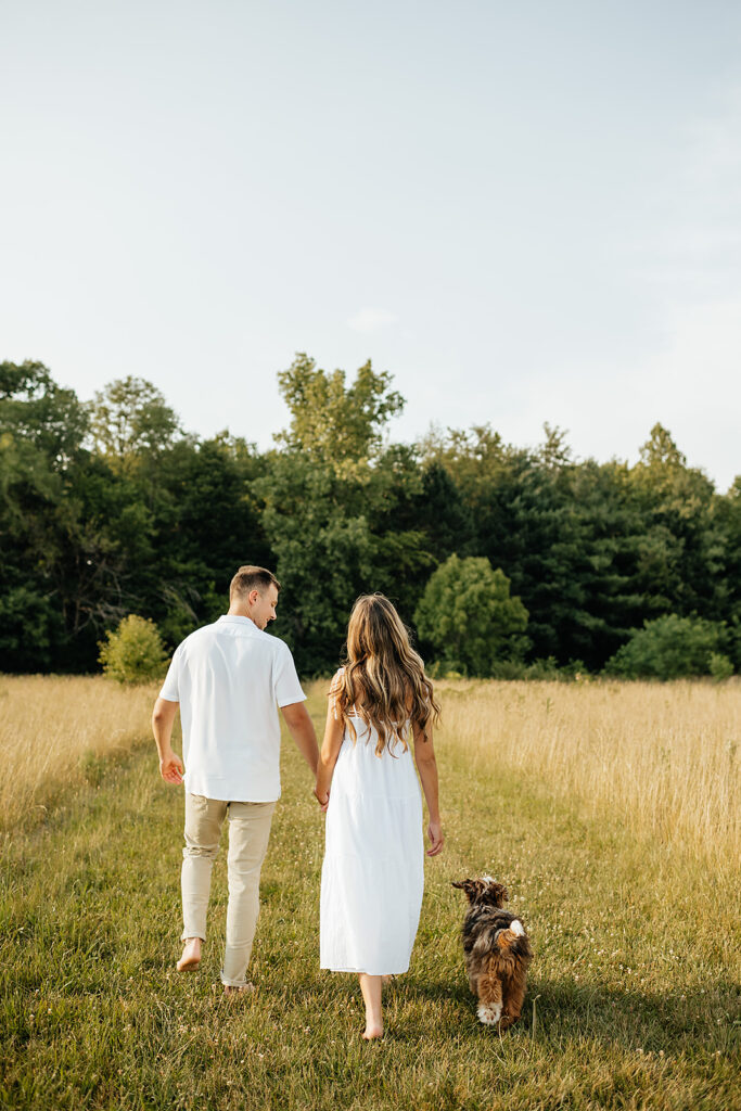 romantic engagement photos in field with dog