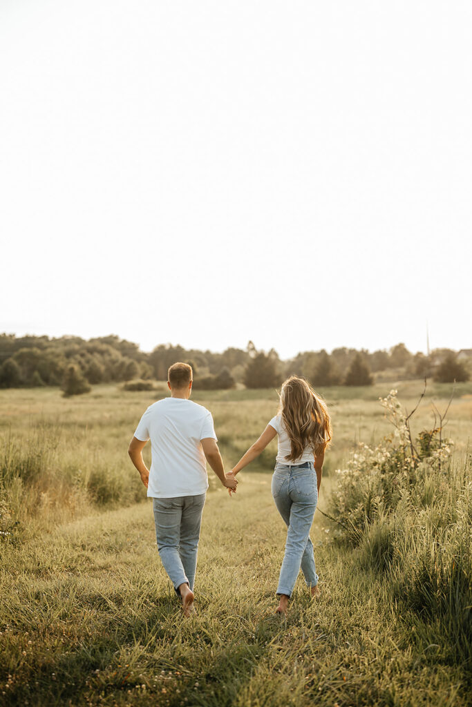 couple walking in field engagement photoshoot ideas