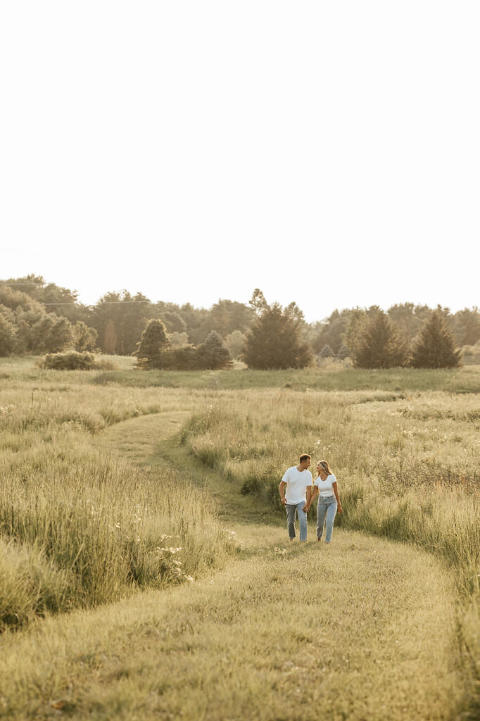 couple walking in field engagement photoshoot ideas