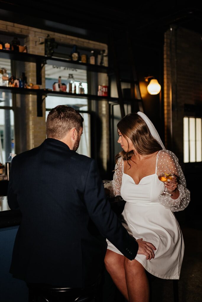 Couple sits at a bar during their hotel engagement photos in Indianapolis