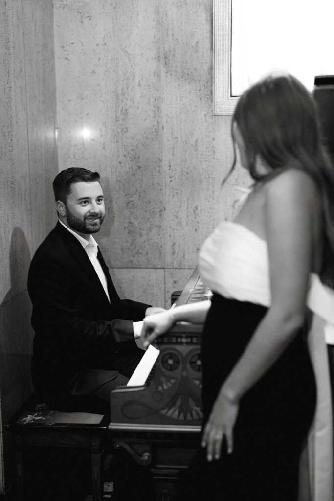 Man plays piano for fiancee during their Bottleworks Hotel engagement photos