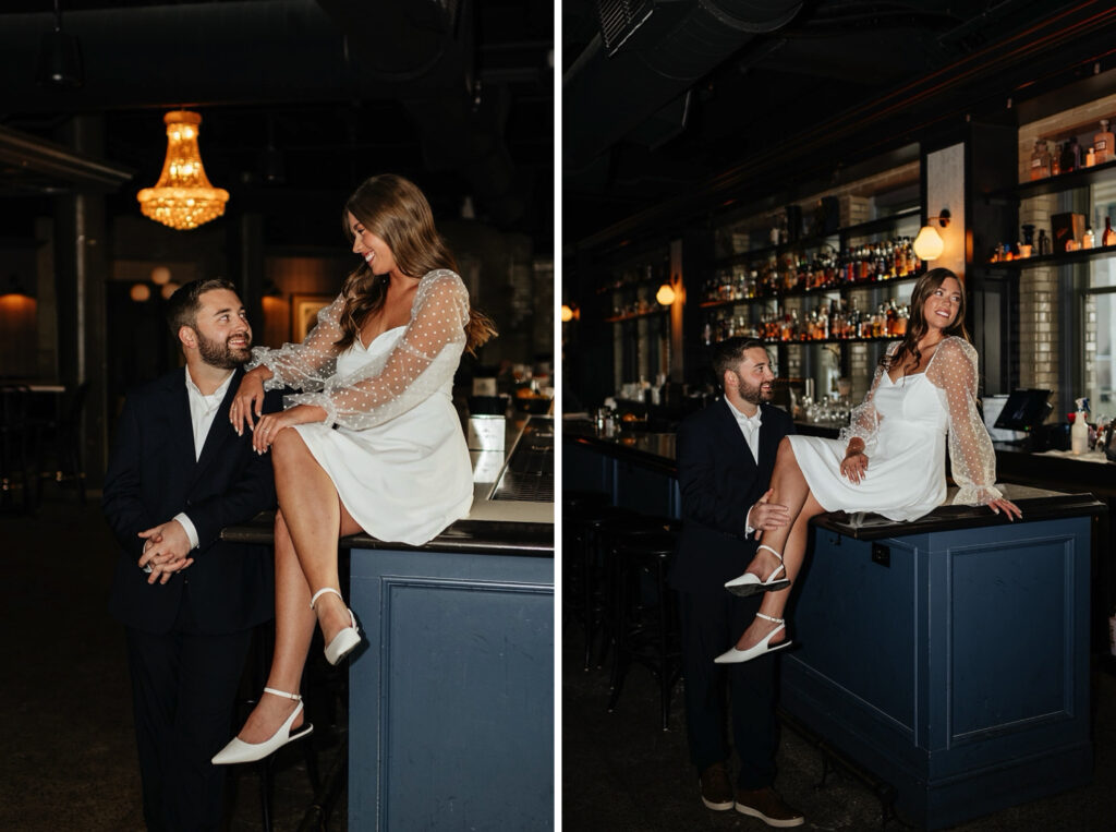 Woman sits on the bartop at a hotel during their engagement session at Bottleworks Hotel