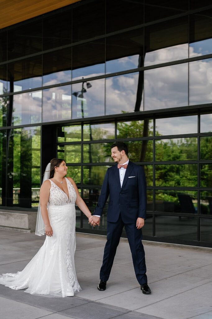 Bride and groom hold hands during their downtown wedding photos in Fort Wayne, Indiana
