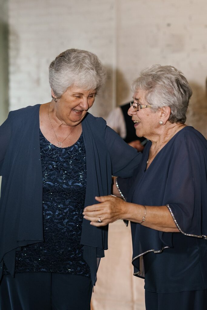 Two elderly women laugh during the dance reception at the Paper Mill