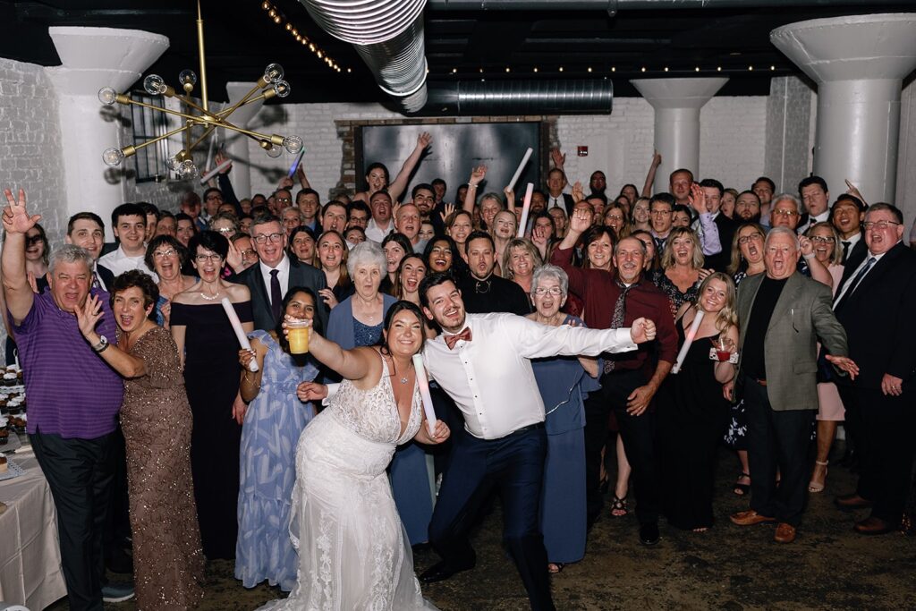 Bride and groom pose with guests on the wedding reception dance floor at their Fort Wayne wedding