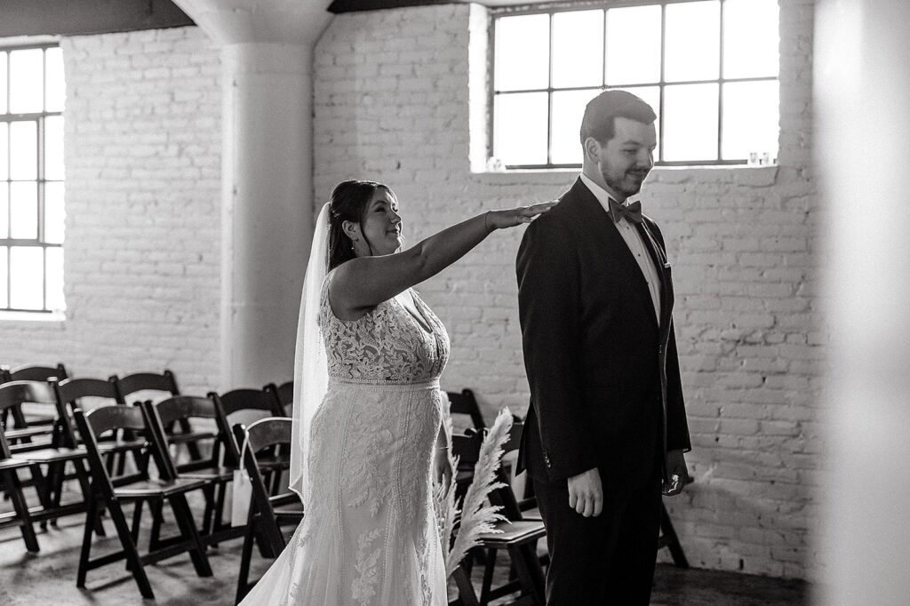 Bride tapping groom on the shoulder for their Fort Wayne wedding first look 
