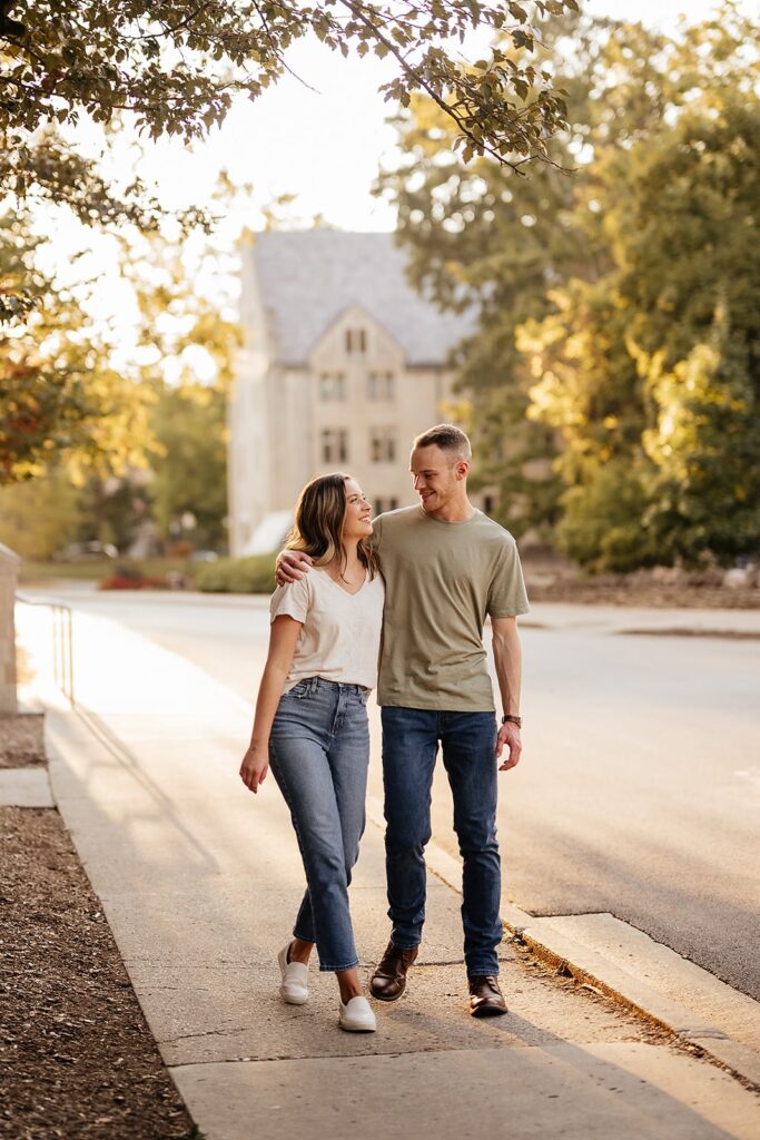 Man and woman walk side by side during their engagement photo session at Indiana University