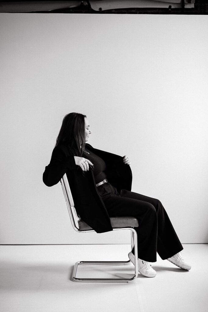 Woman sitting in a mid-century chair during her studio branding session in Indiana