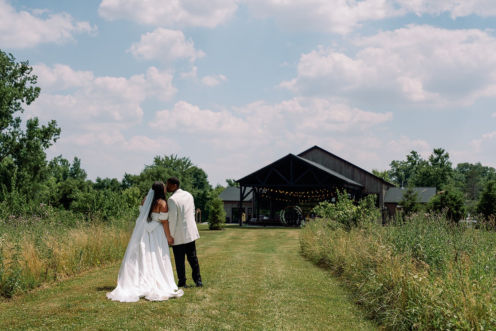 Bride and groom kiss on the lawn at their Union 12 wedding in Indiana