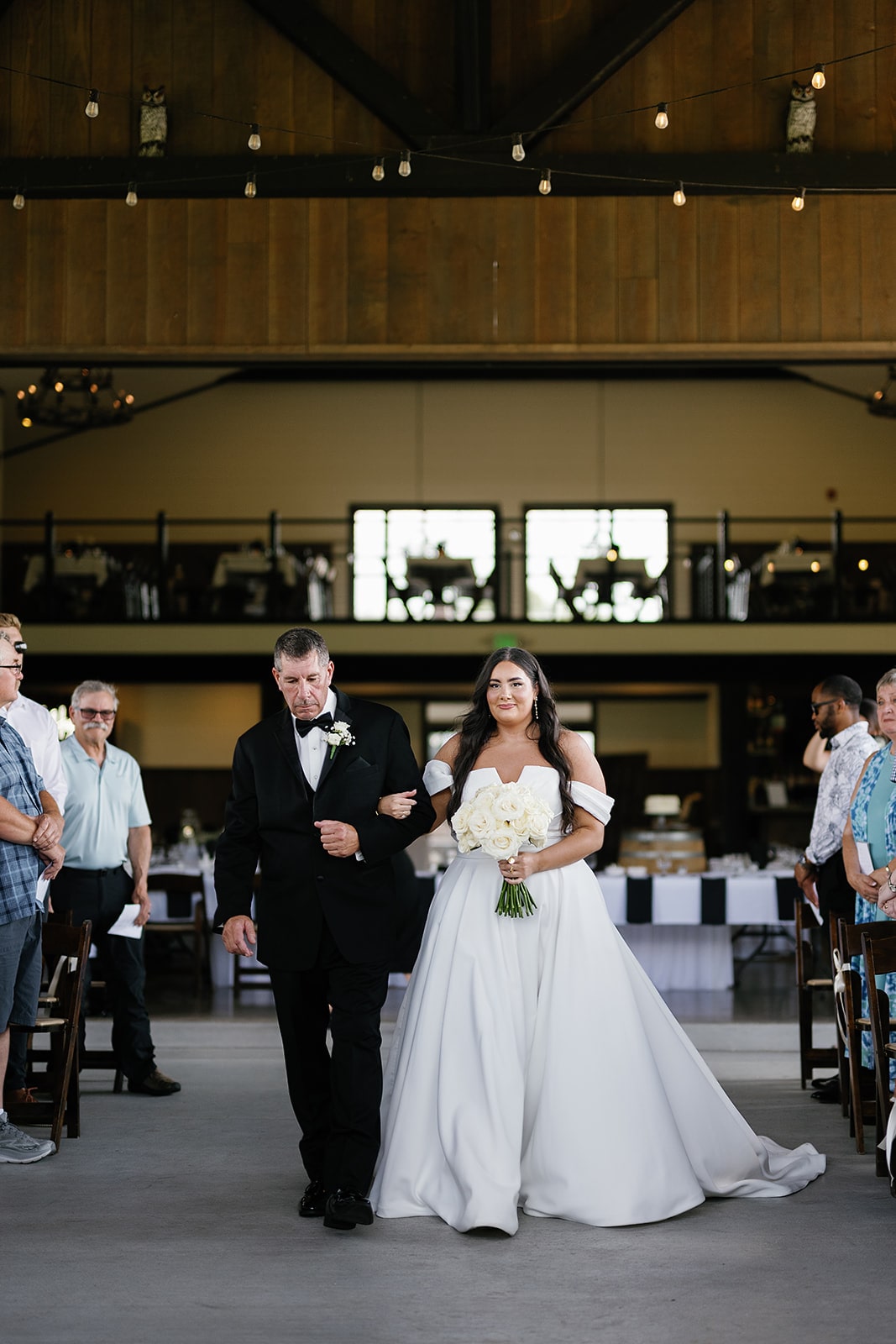 Bride holds the arm of her father while walking down the aisle at Union 12 wedding venue