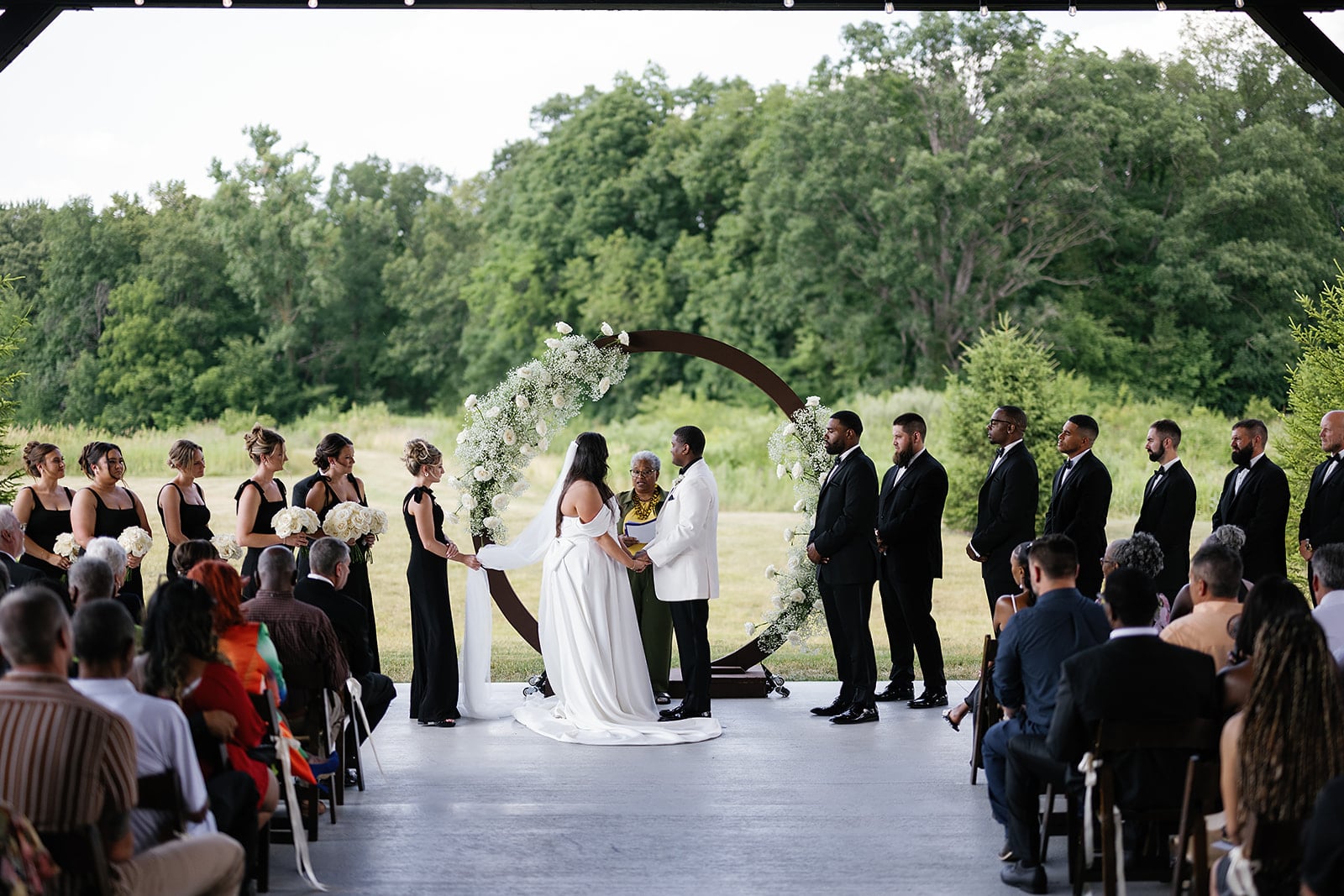 Bride and groom hold hands at the altar during their timeless Midwest wedding 