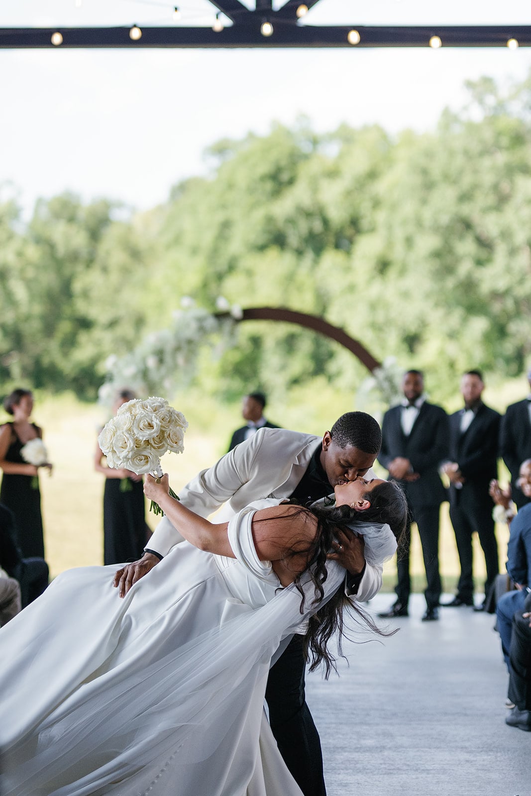 Groom dips bride for a kiss after their black and white wedding ceremony at Union 12