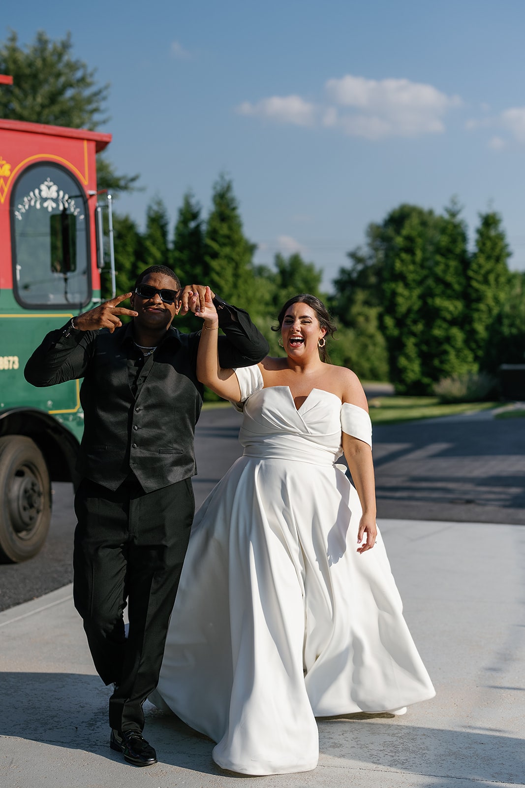 Bride and groom cheer as they exit a trolly during their Midwest wedding 