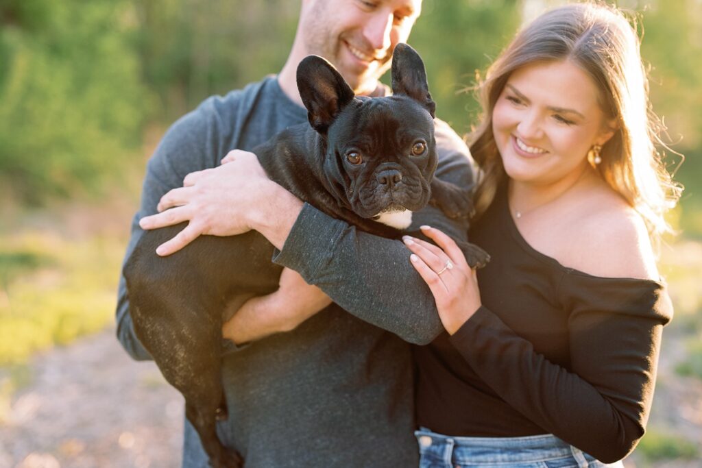 Couple holds their black Frenchie pup during their engagement session in Indianapolis