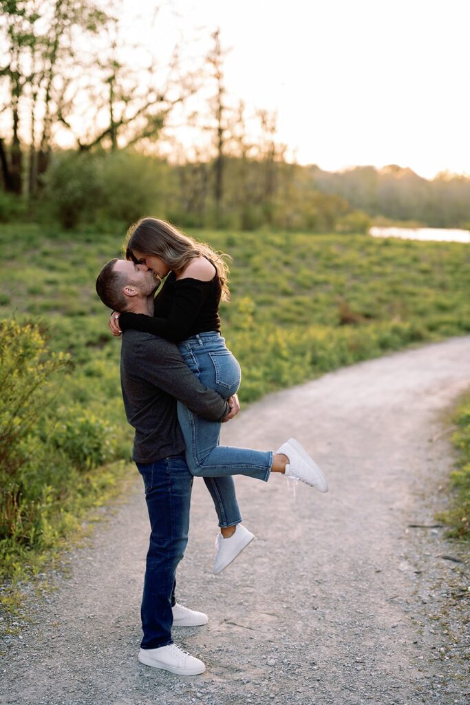 Couple kisses on a gravel trail during their Newfields engagement photo session 