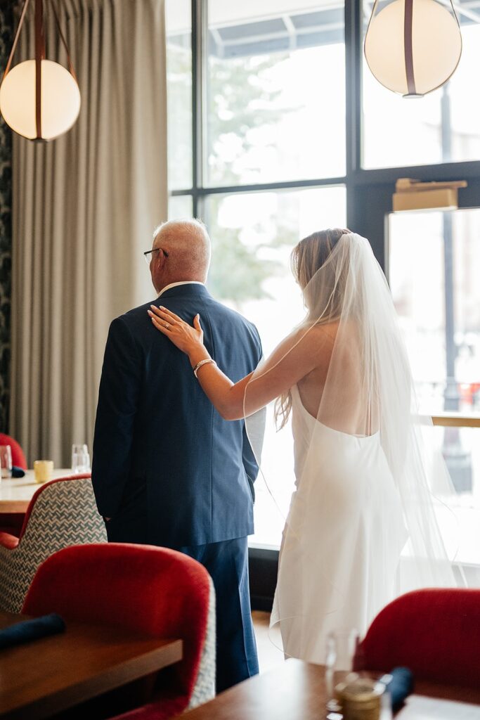 Bride taps father on the should during their first look