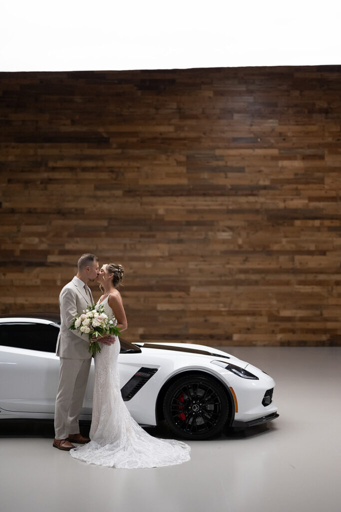 Bride and grooms portraits with their white Chevy corvette at Kruse Plaza wedding venue in Auburn, Indiana