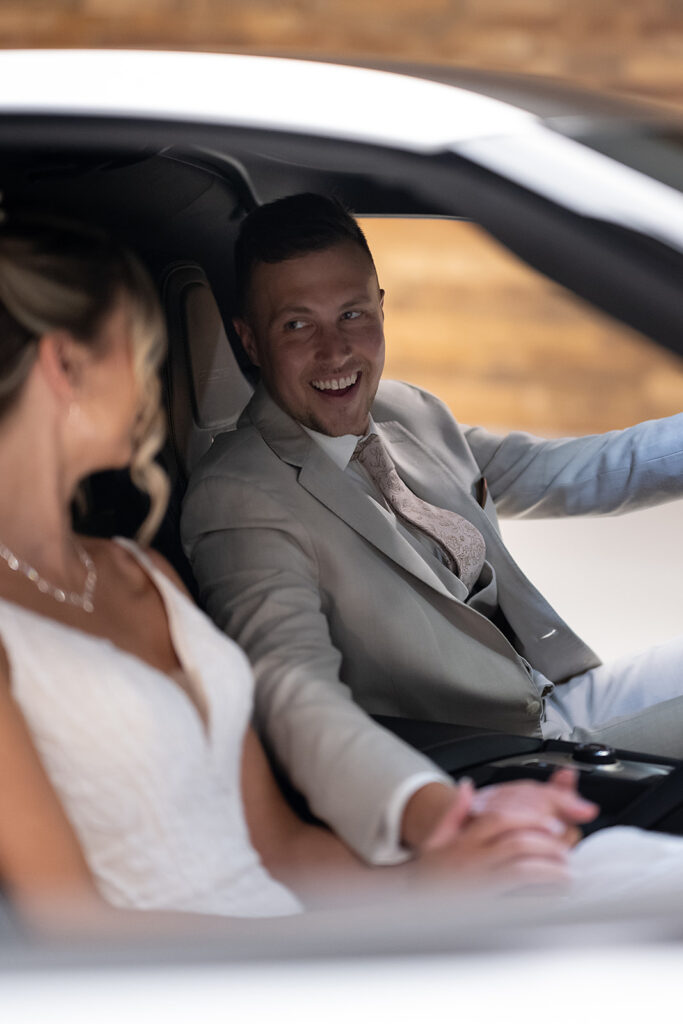 Bride and grooms portraits inside their white Chevy corvette at Kruse Plaza wedding venue in Auburn, Indiana