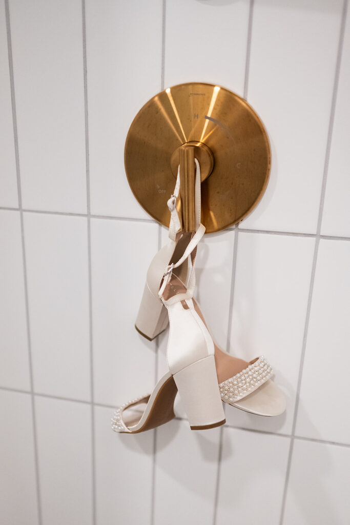 Brides wedding heels hanging from a shower handle