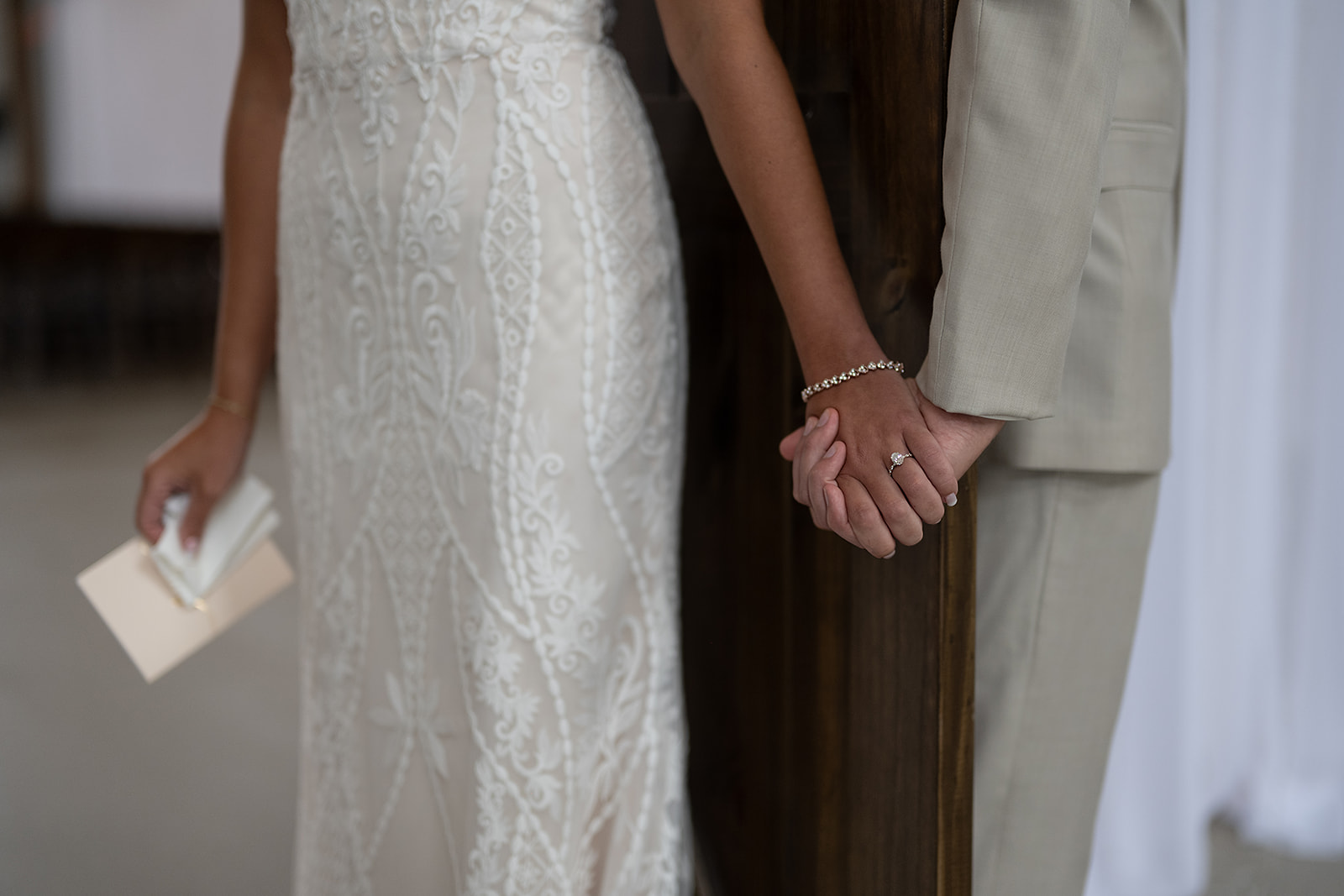 Bride and groom holding hands during their first touch