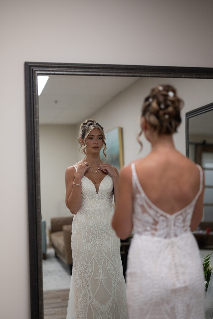 Bride looking at herself in the mirror as she gets ready