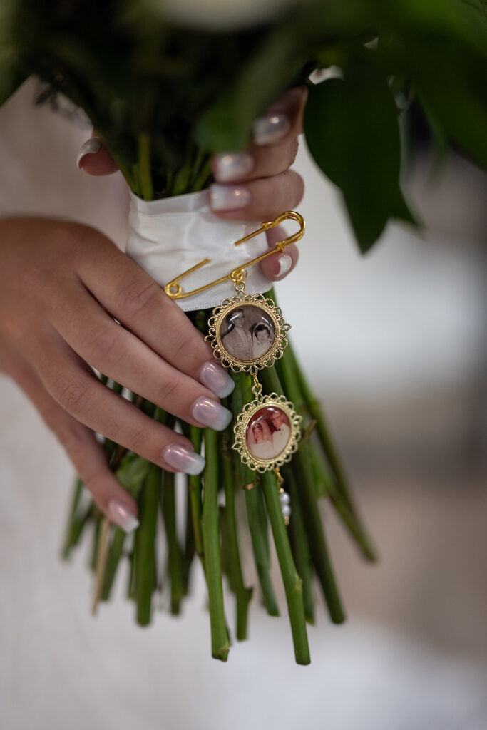 Bride holding her wedding bouquet with memorial pictures