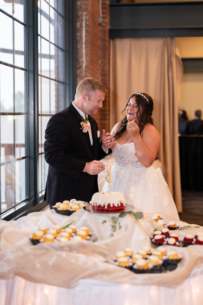 Bride and groom laughing as they cut into their wedding bundt cake