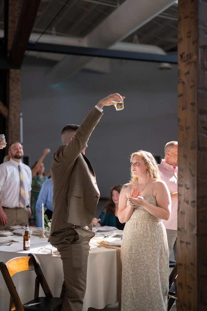 Wedding guest raising his glass during speeches