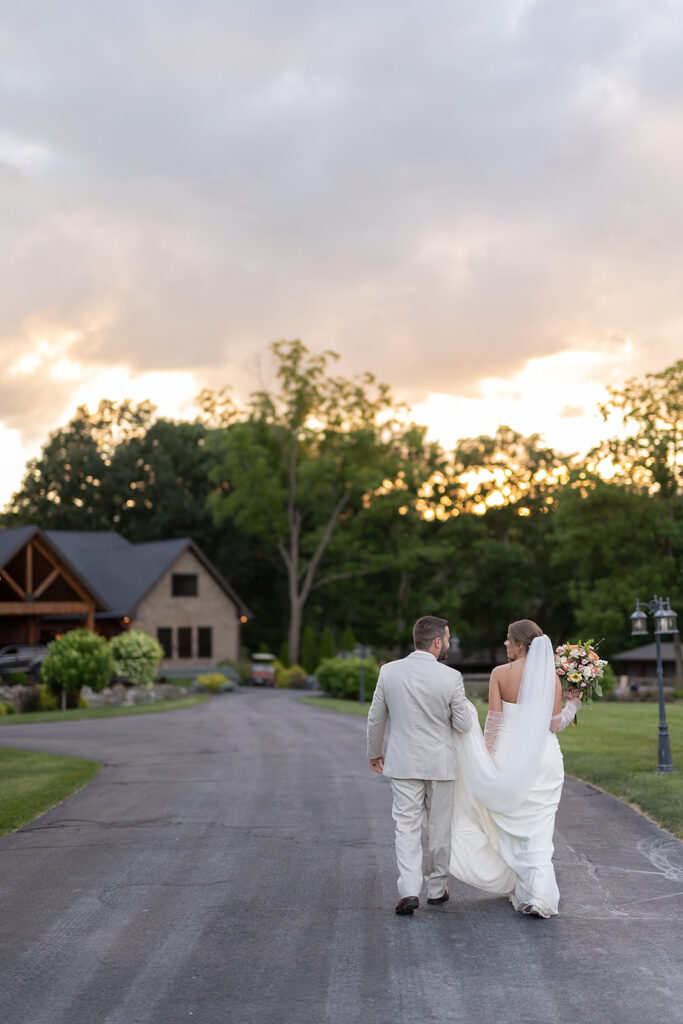 Bride and groom walking back at Stone Creek Lodge wedding venue after their golden hour portraits