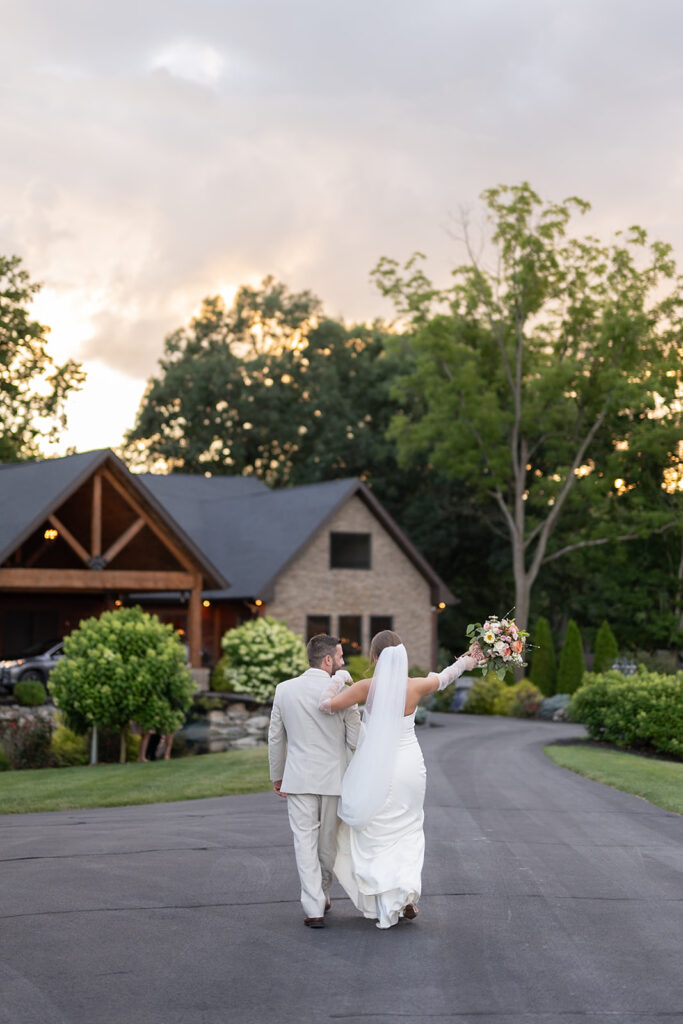 Bride and groom walking back at Stone Creek Lodge wedding venue after their golden hour portraits