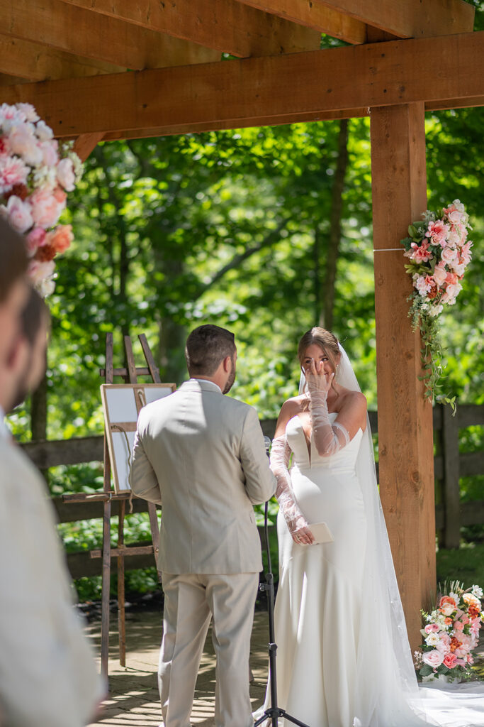 Bride getting emotional during their outdoor Stone Creek Lodge wedding ceremony