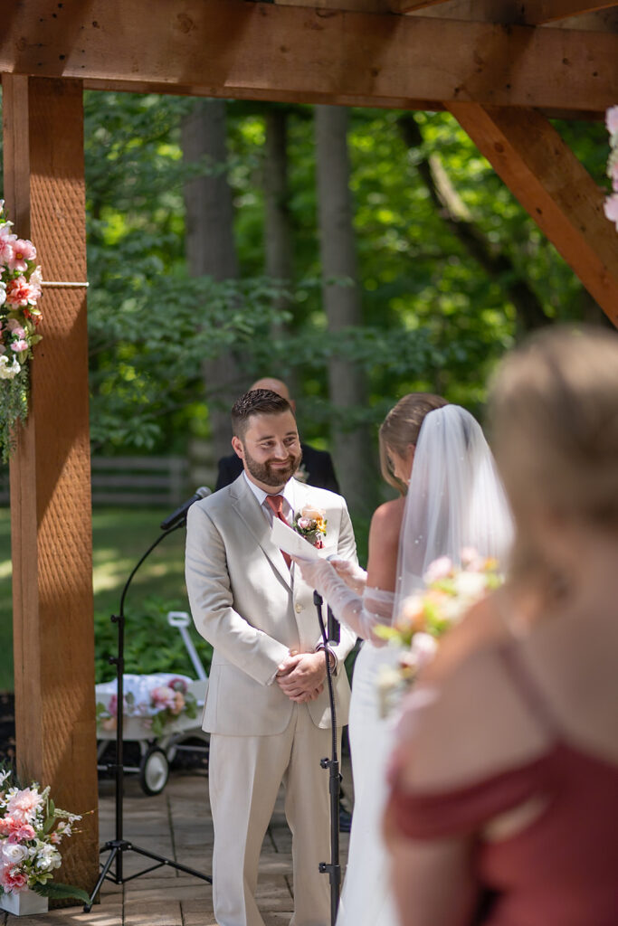 Bride reading vows during outdoor Stone Creek Lodge wedding ceremony