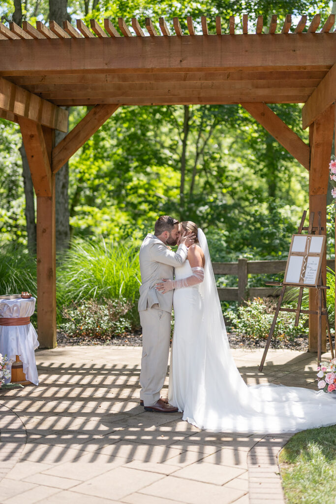 Bride and groom kissing during their outdoor Stone Creek Lodge wedding ceremony