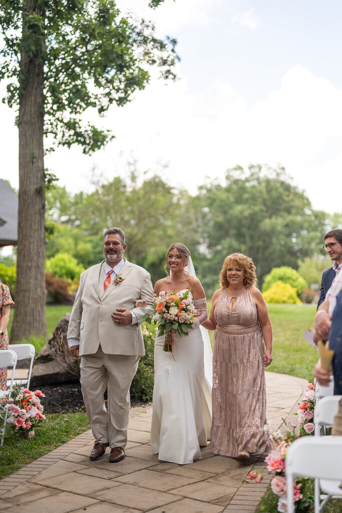 Bride being walked down the aisle by her parents