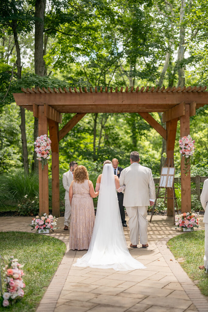 Bride being walked down the aisle by her parents