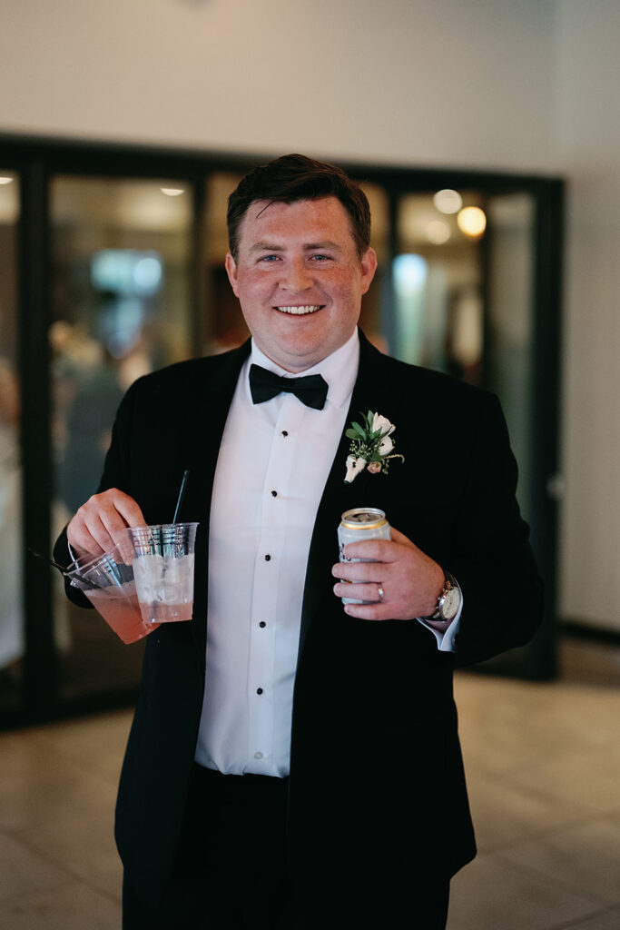 Groom holding onto drinks