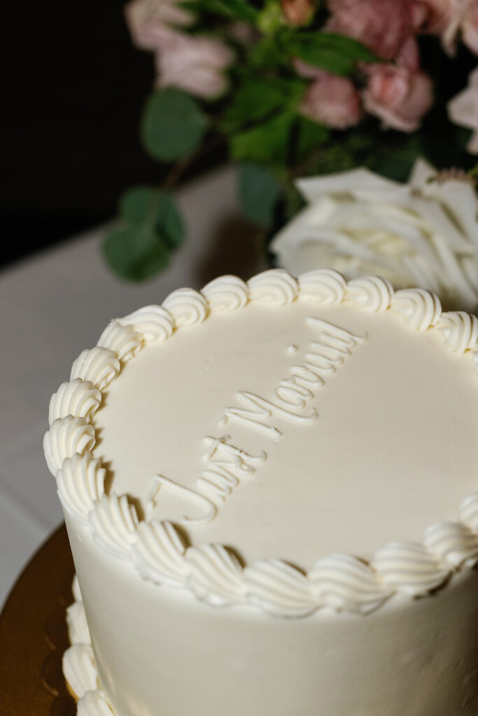 All white wedding cake that says 'Just Married!'