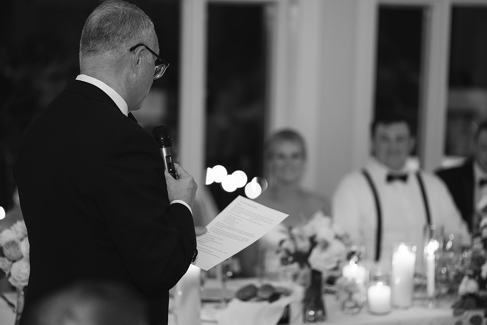 Black and white photo of wedding speeches during the reception