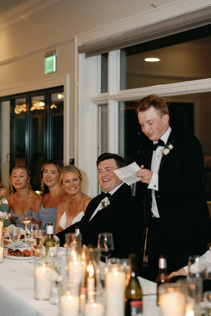 Bride and groom smiling during wedding speeches