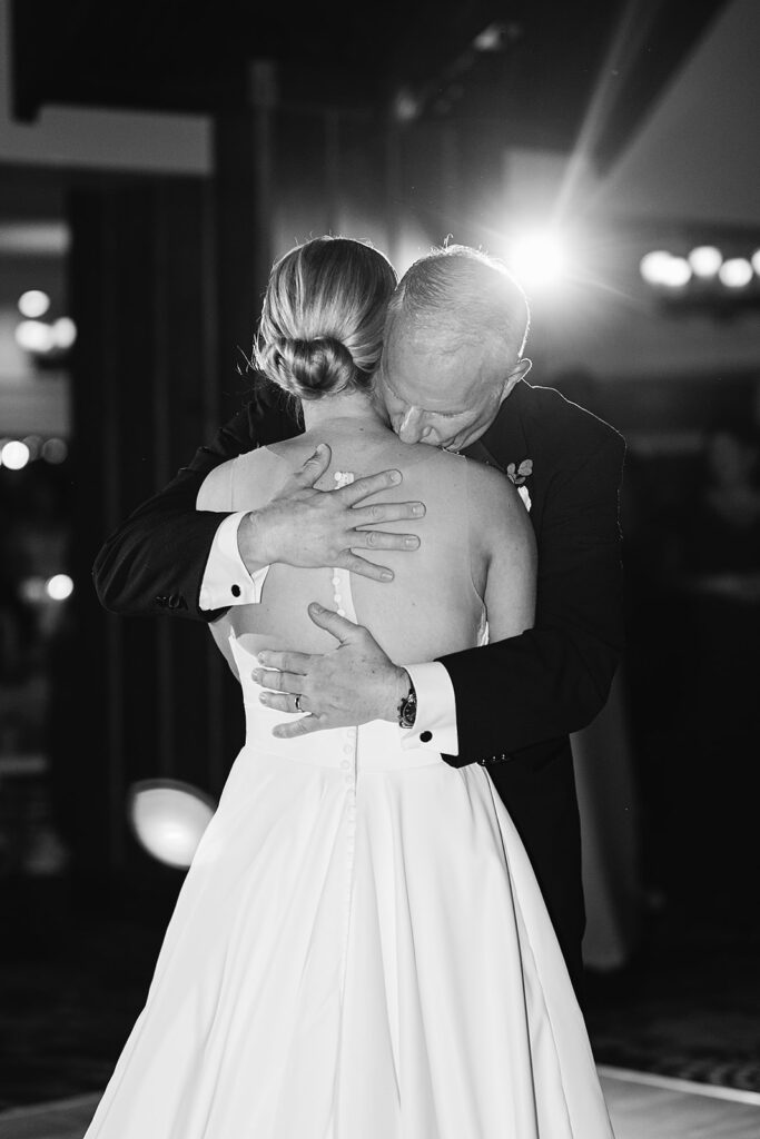 Black and white photo of a bride dancing with her father