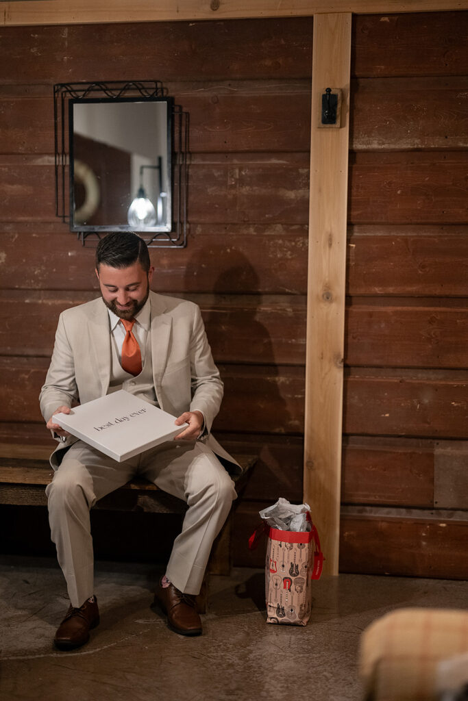 Groom opening a gift from the bride